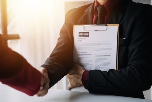 Candidate holding resume and shaking hands