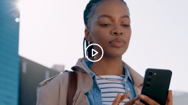 Mujer mirando su teléfono móvil con la luz del sol detrás de ella